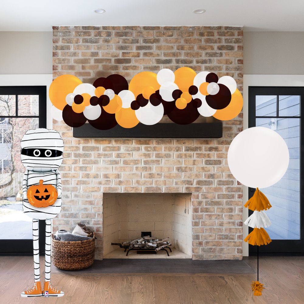 Halloween-themed decorations including a mummy figure, balloons, and a decorative garland above a fireplace.