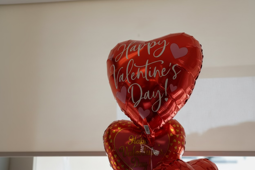 Red heart-shaped balloons with &