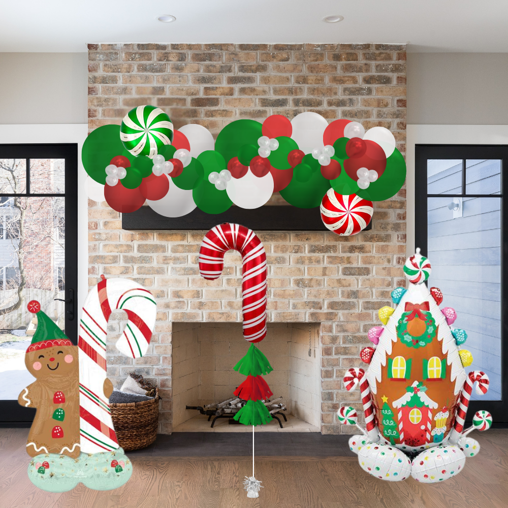 Christmas-themed decorations including balloons and a gingerbread man in front of a brick fireplace.