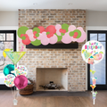 Decorative birthday balloons and streamer on a brick fireplace