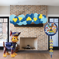 Paw Patrol-themed balloons and a balloon with a character in front of a fireplace.